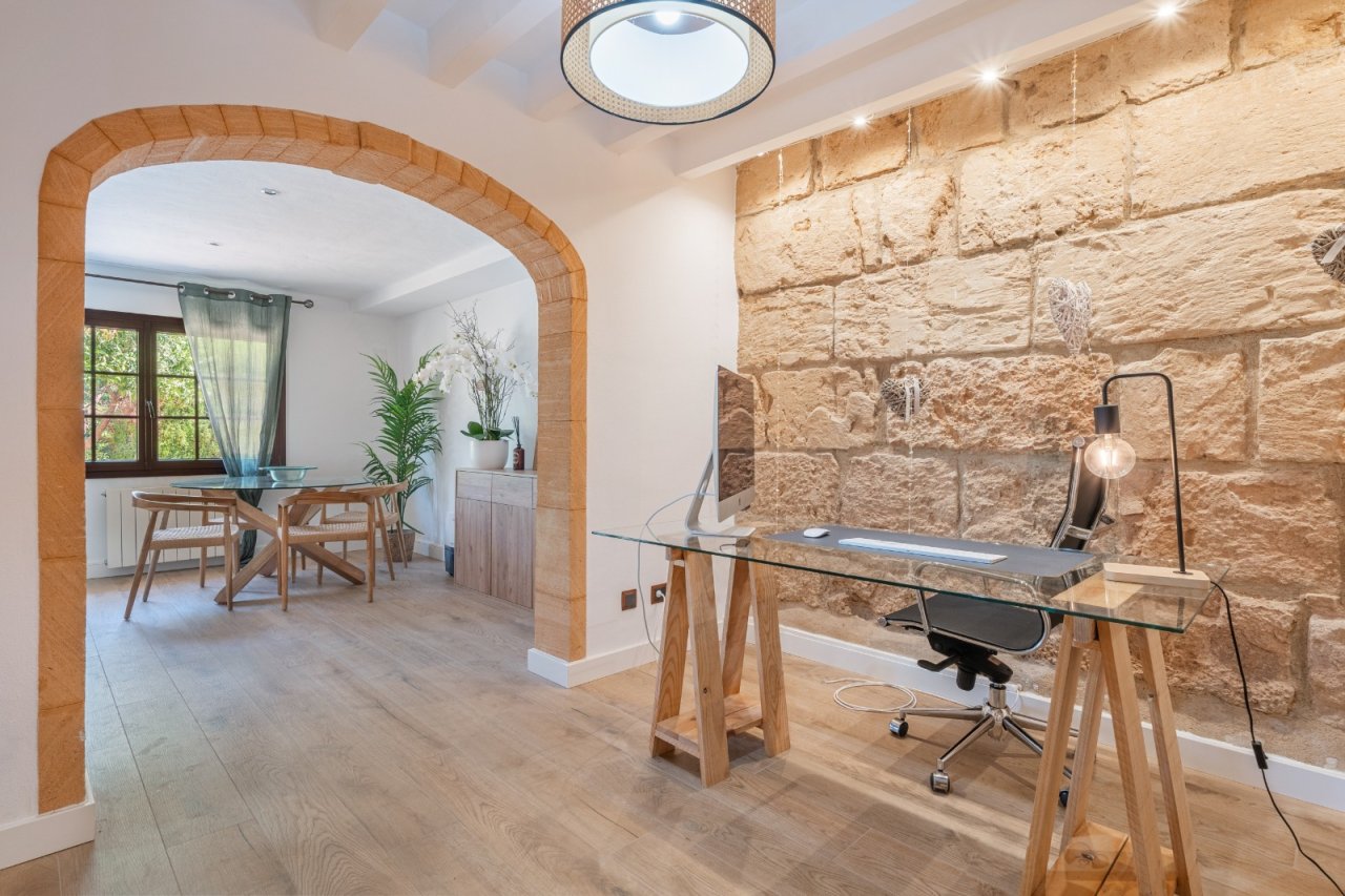 Modern home office with a distinctive natural stone wall and flexible room layout