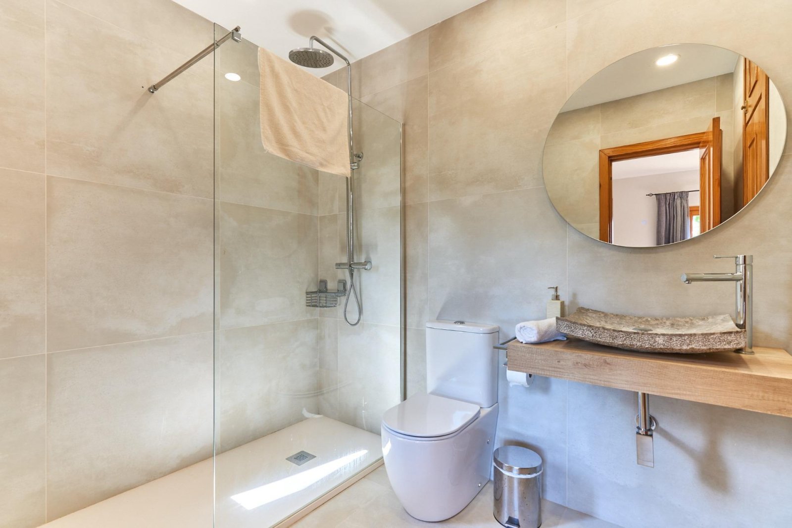 Modern bathroom with walk-in shower, natural stone sink, and high-quality sanitary fittings Modern bathroom with walk-in shower, natural stone sink, and high-quality sanitary fittings