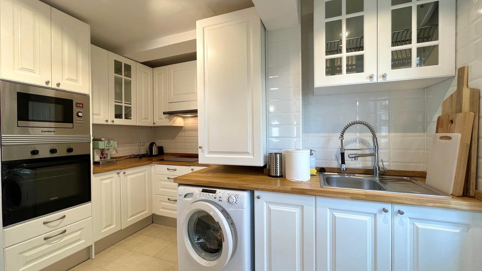 Modern kitchen with built-in washing machine and practical sink area Modern kitchen with built-in washing machine and practical sink area