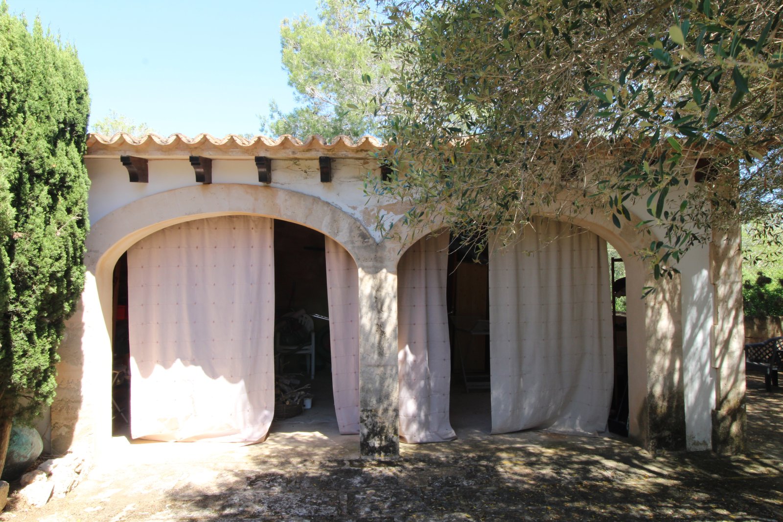 Covered loggias with massive round-arch arcades and shaded outdoor area