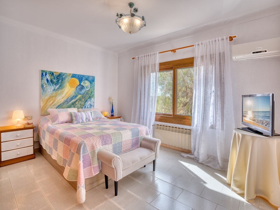 Bright bedroom with air conditioning, wooden windows, and optimal room layout.