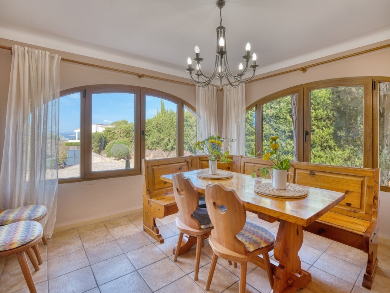 Dining room with elegant rounded arch windows and a clear view of the landscape