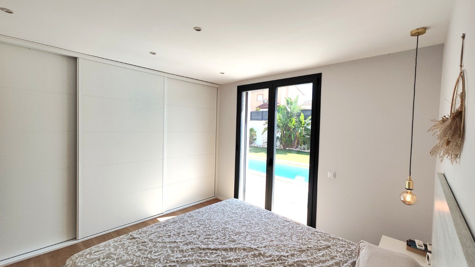 Main bedroom with floor-to-ceiling glass sliding doors and built-in wardrobes
