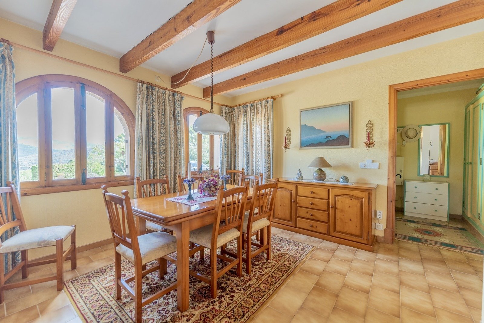 Dining room with a characterful wooden beam ceiling and large panoramic windows Dining room with a characterful wooden beam ceiling and large panoramic windows