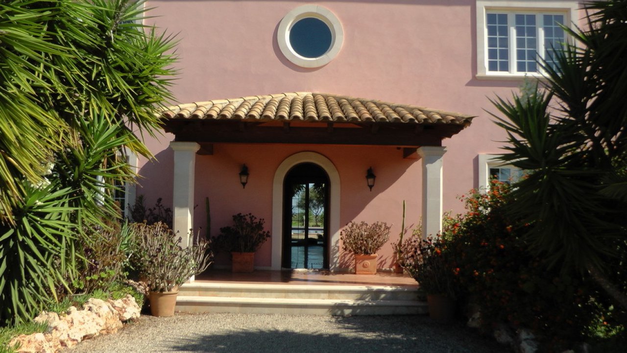 Welcoming entrance with classical columns and a well-designed terrace roof