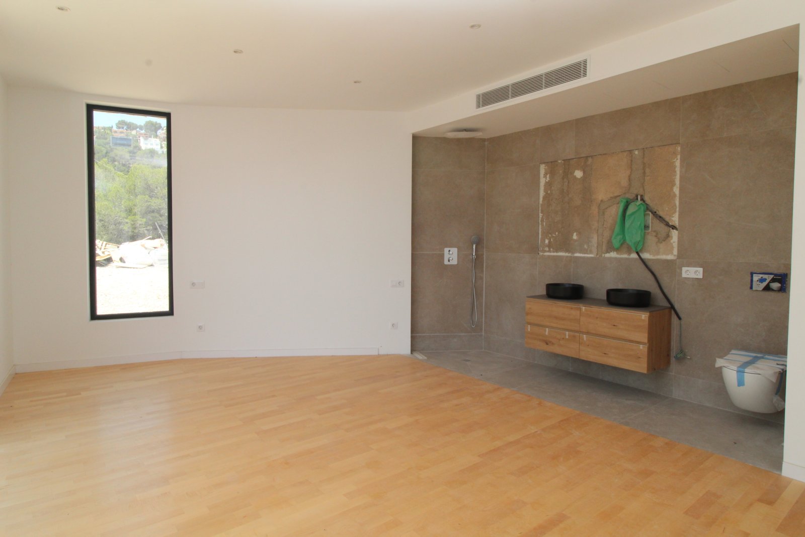 Open bedroom with direct access to the modern bathroom.