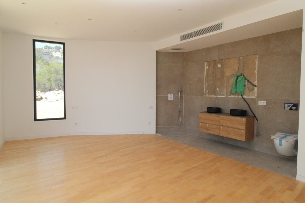 Open bedroom with direct access to the modern bathroom.