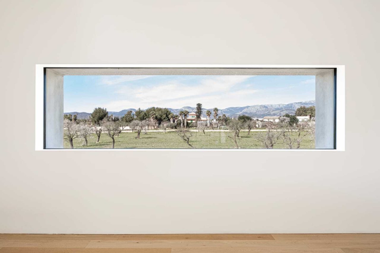 Panoramic window with a clear view of the olive grove landscape and mountain backdrop Panoramic window with a clear view of the olive grove landscape and mountain backdrop