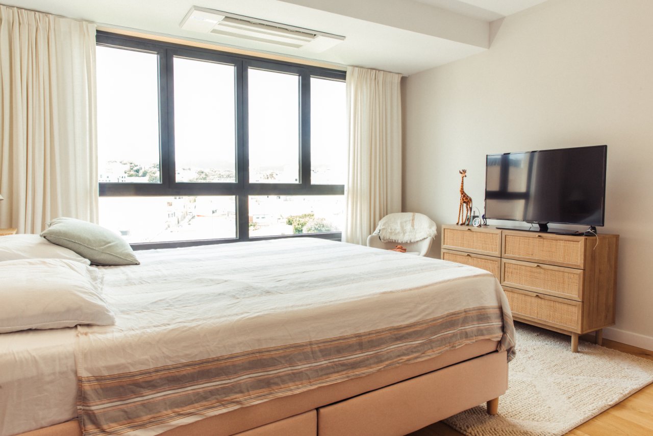 Bright bedroom with floor-to-ceiling windows and optimal daylight utilization