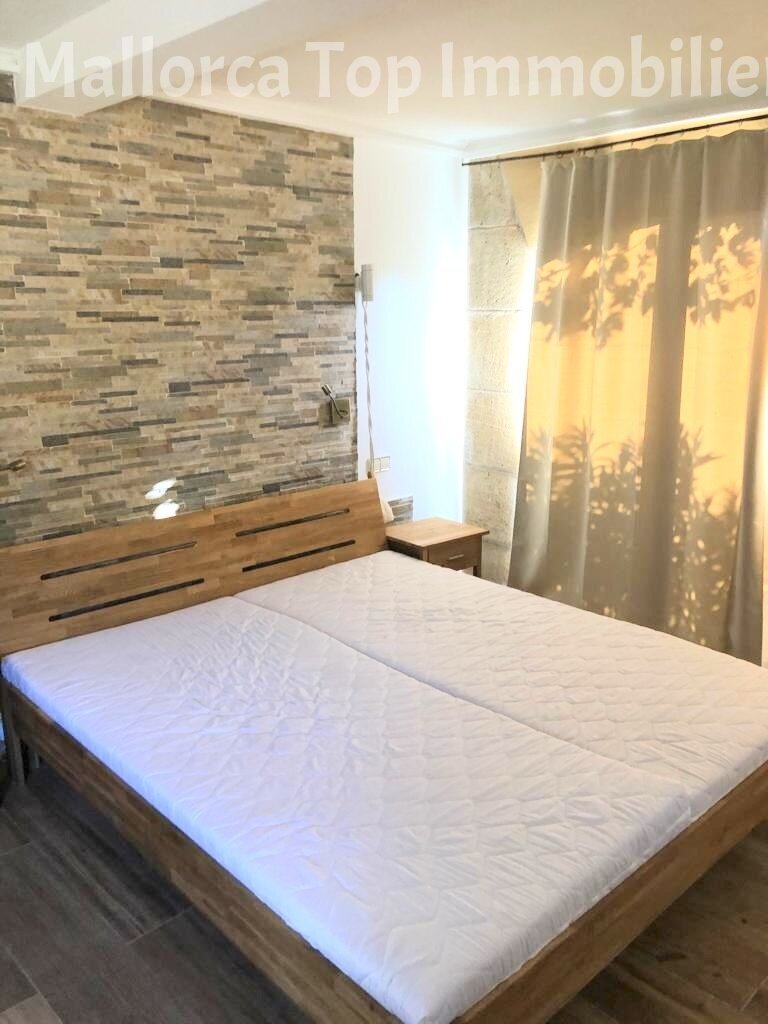 Comfortable bedroom with high-quality natural stone wall design and large window features