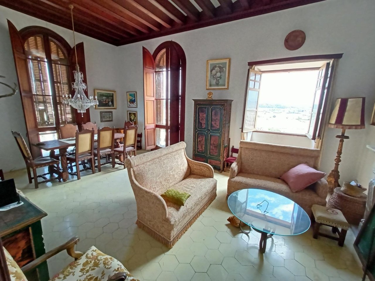 Living area with open floor plan – connection of salon and dining area under a coffered wooden ceiling