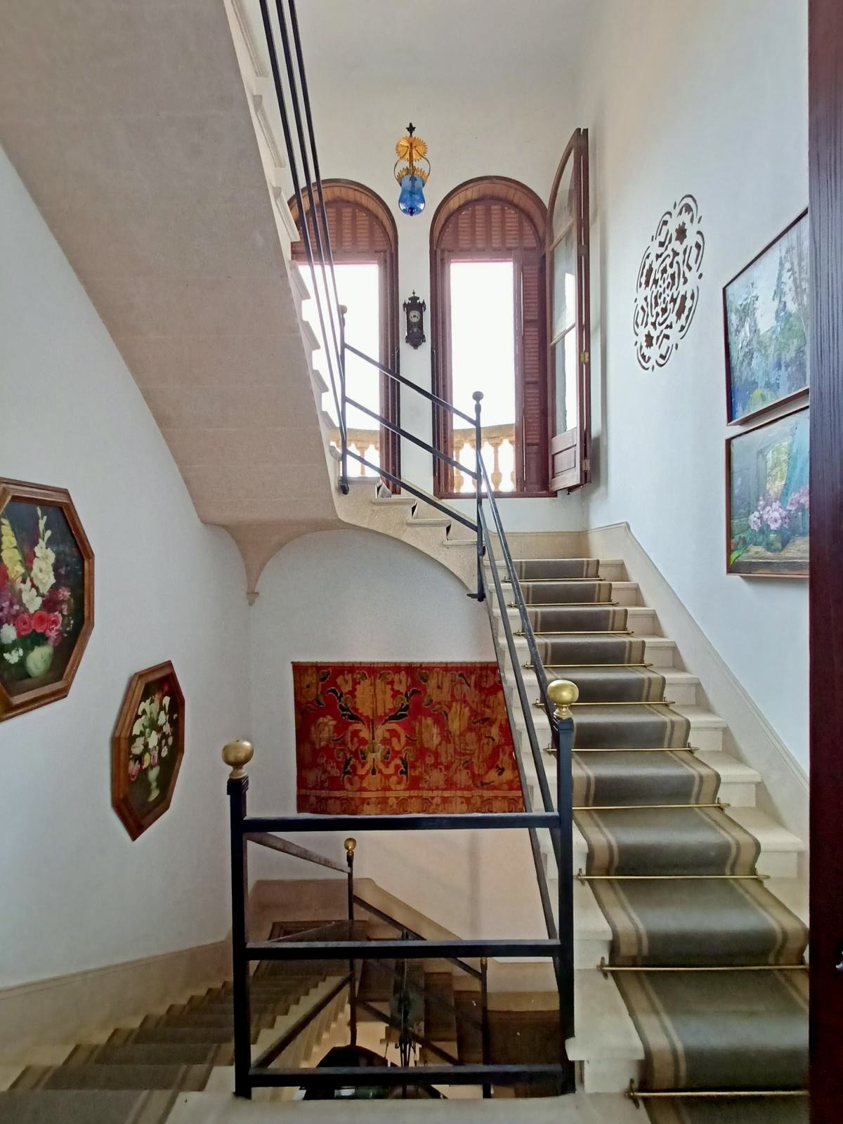 Imposing staircase with natural stone flooring and brass handrail – connecting element between the floors with architectural elegance