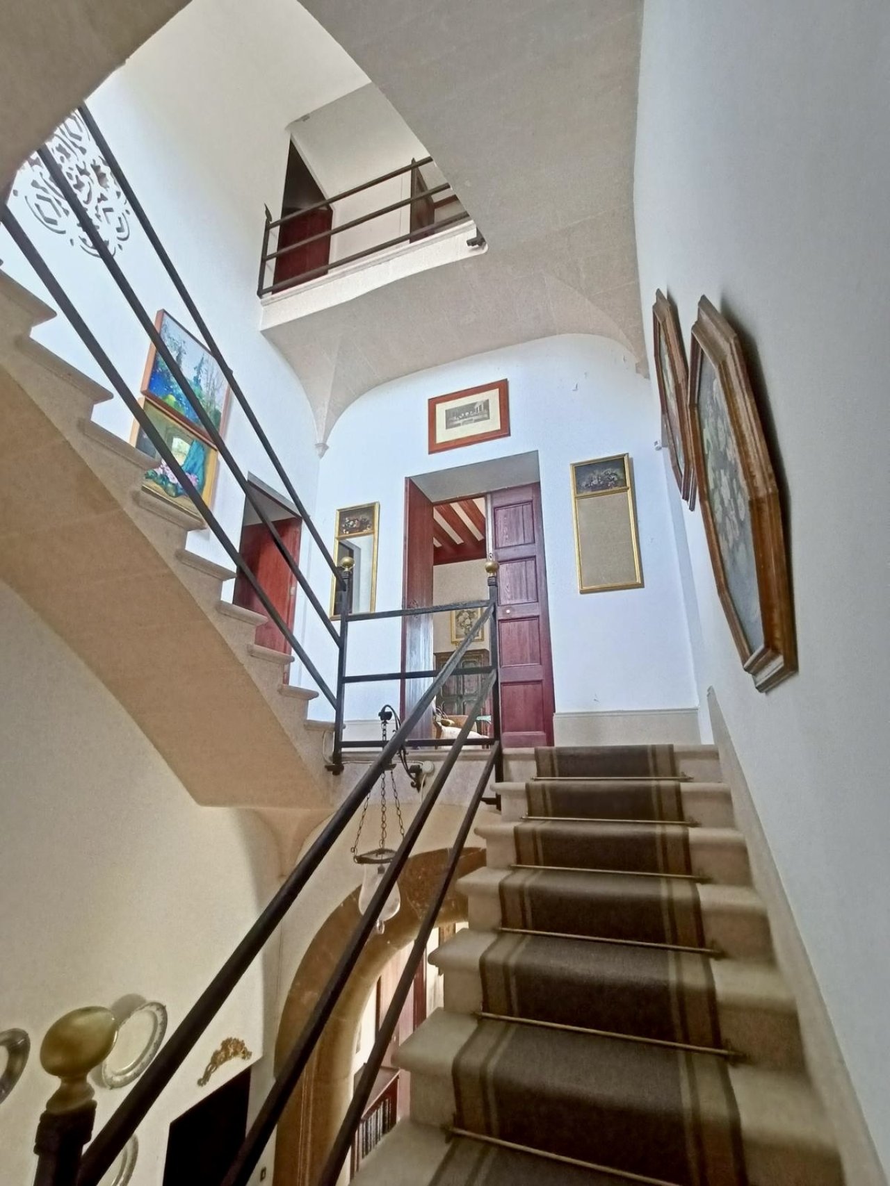 Brightly lit staircase with elegant wooden steps and brass railing – connecting all floors with harmonious spatial effect