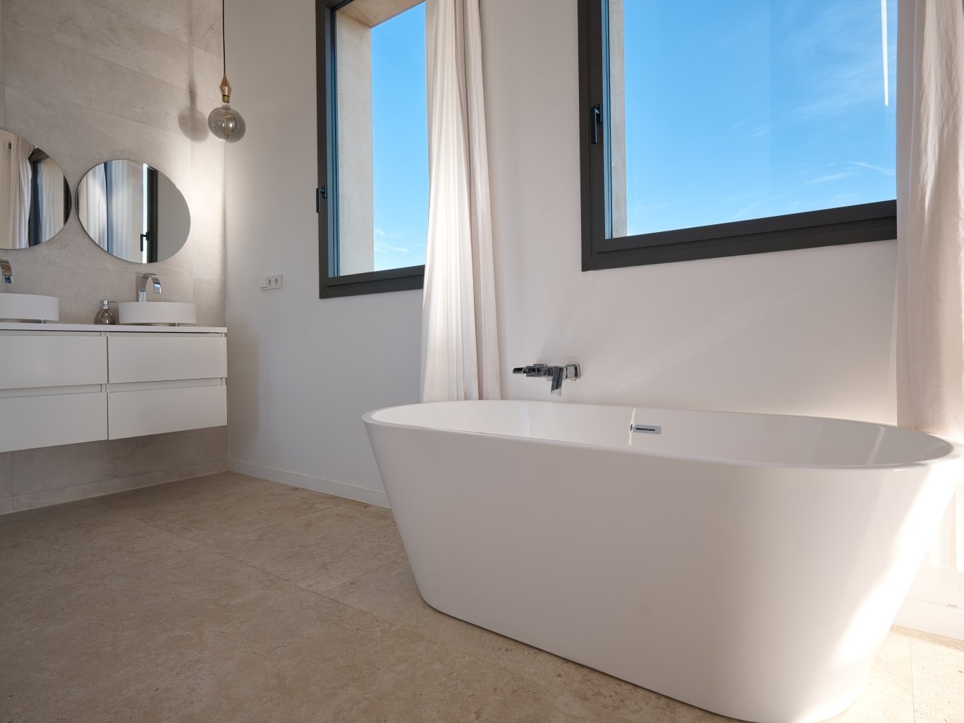 Luxurious bathroom with freestanding bathtub and panoramic windows.
