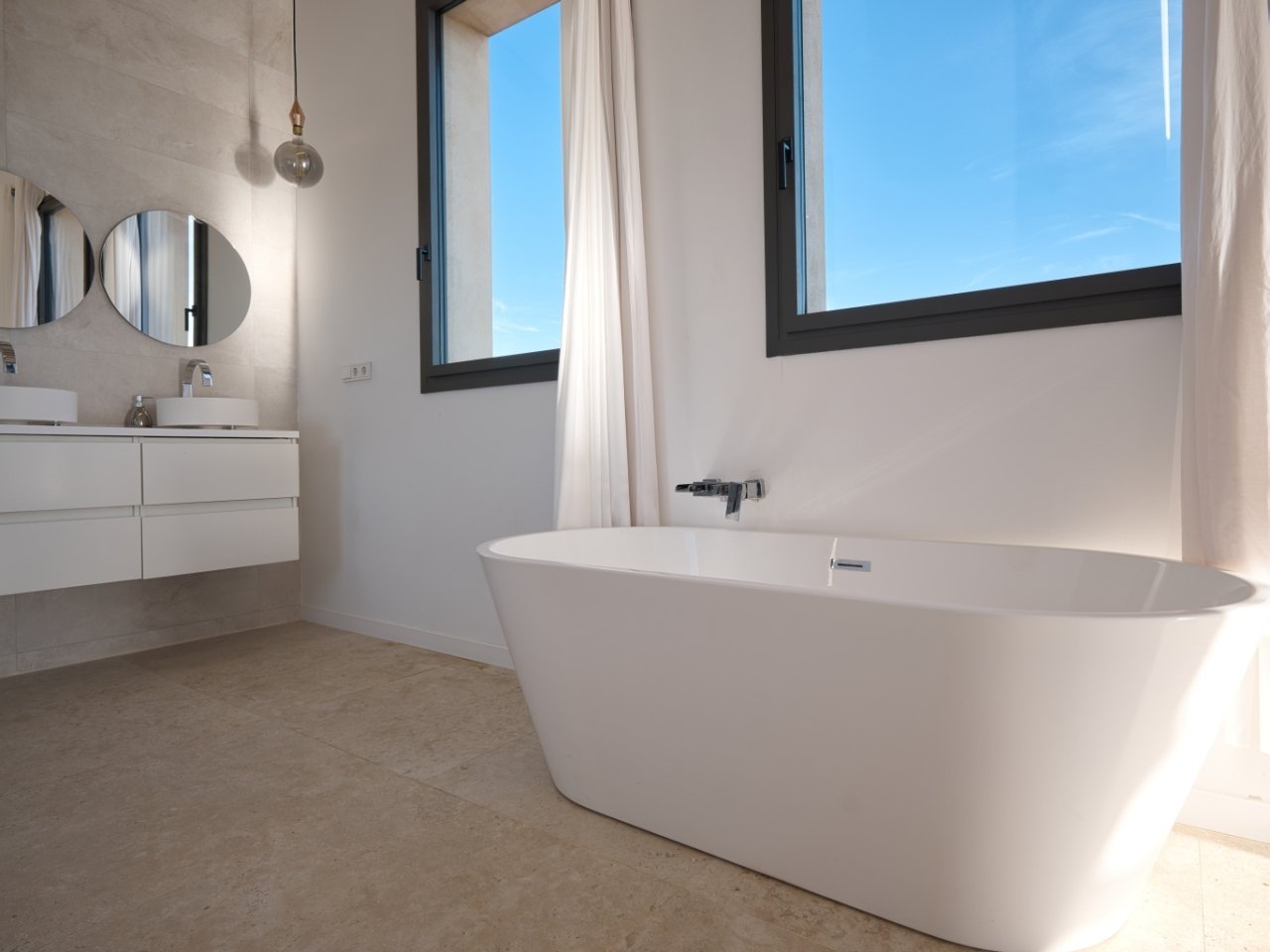 Luxurious bathroom with freestanding bathtub and panoramic windows.