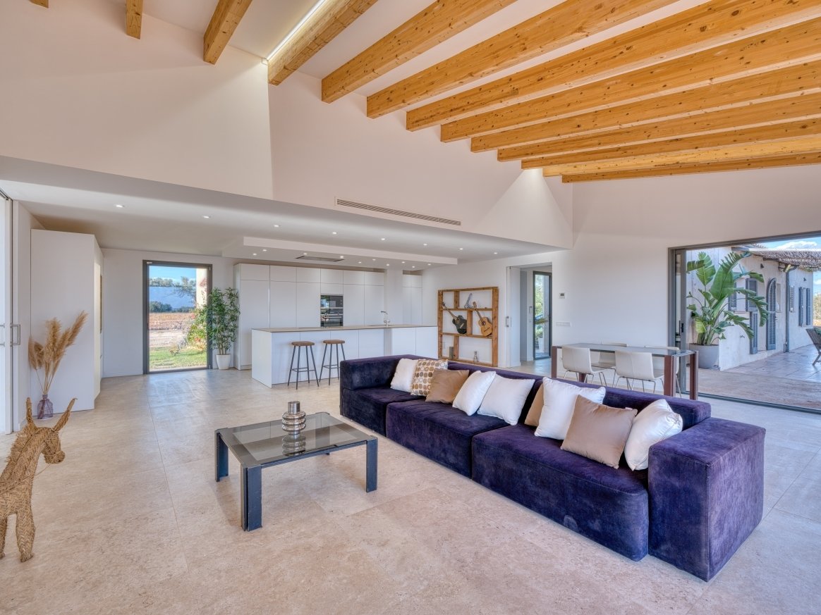 Open living concept with a characterful wooden beam ceiling and seamless transitions to the kitchen and outdoor areas