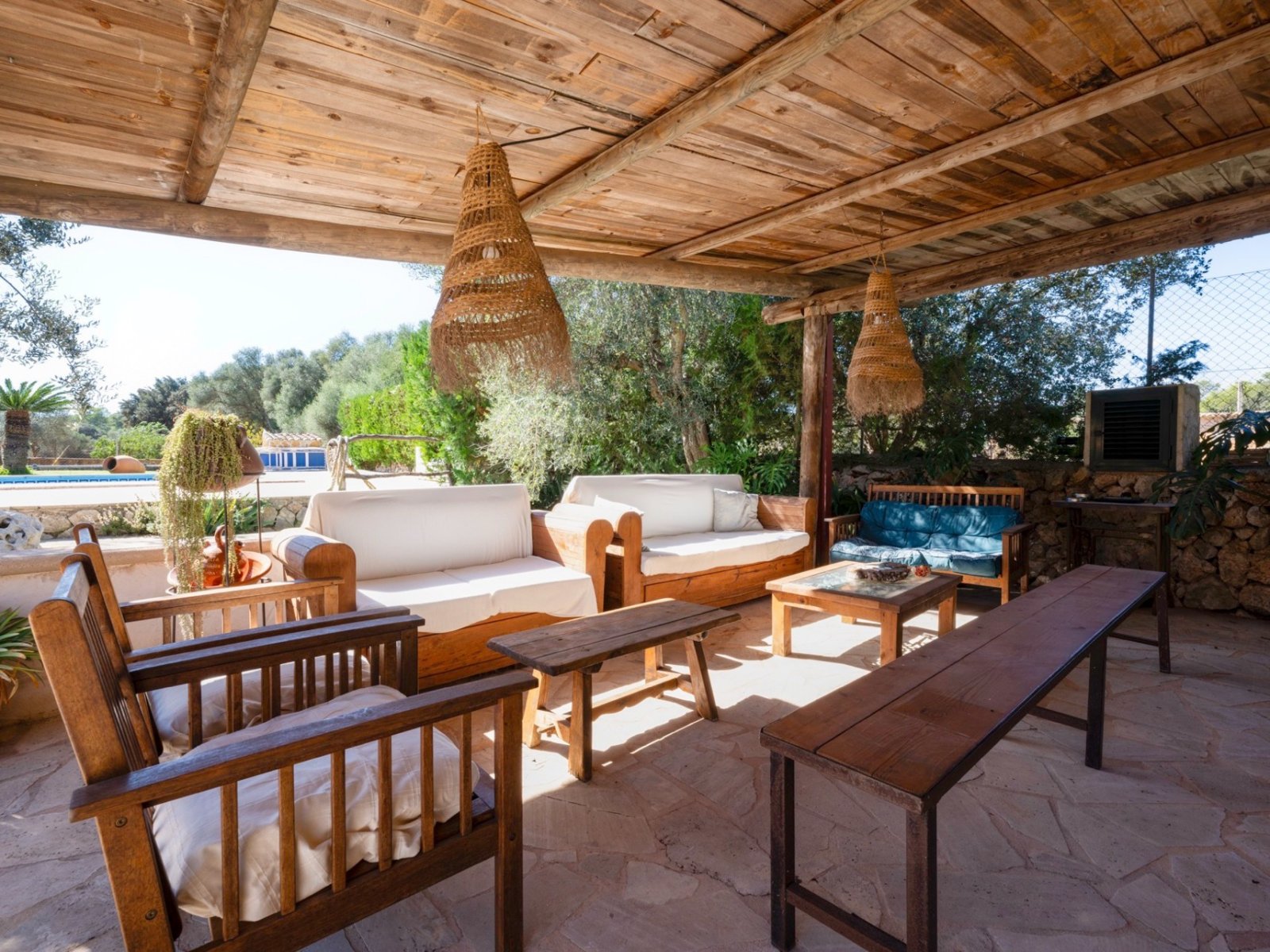 Covered lounge terrace with rustic wooden beams and a open view of the greenery Covered lounge terrace with rustic wooden beams and a open view of the greenery