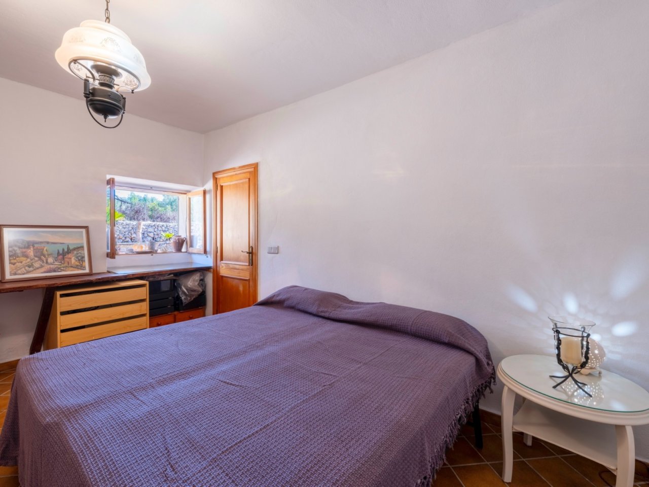 Comfortable bedroom with windowsill, practical workspace, and elegant ceiling light. Comfortable bedroom with windowsill, practical workspace, and elegant ceiling light.