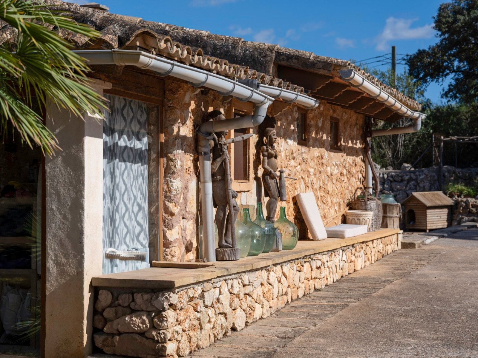 Rustic natural stone facade with a distinctive roof overhang and modern drainage system Rustic natural stone facade with a distinctive roof overhang and modern drainage system