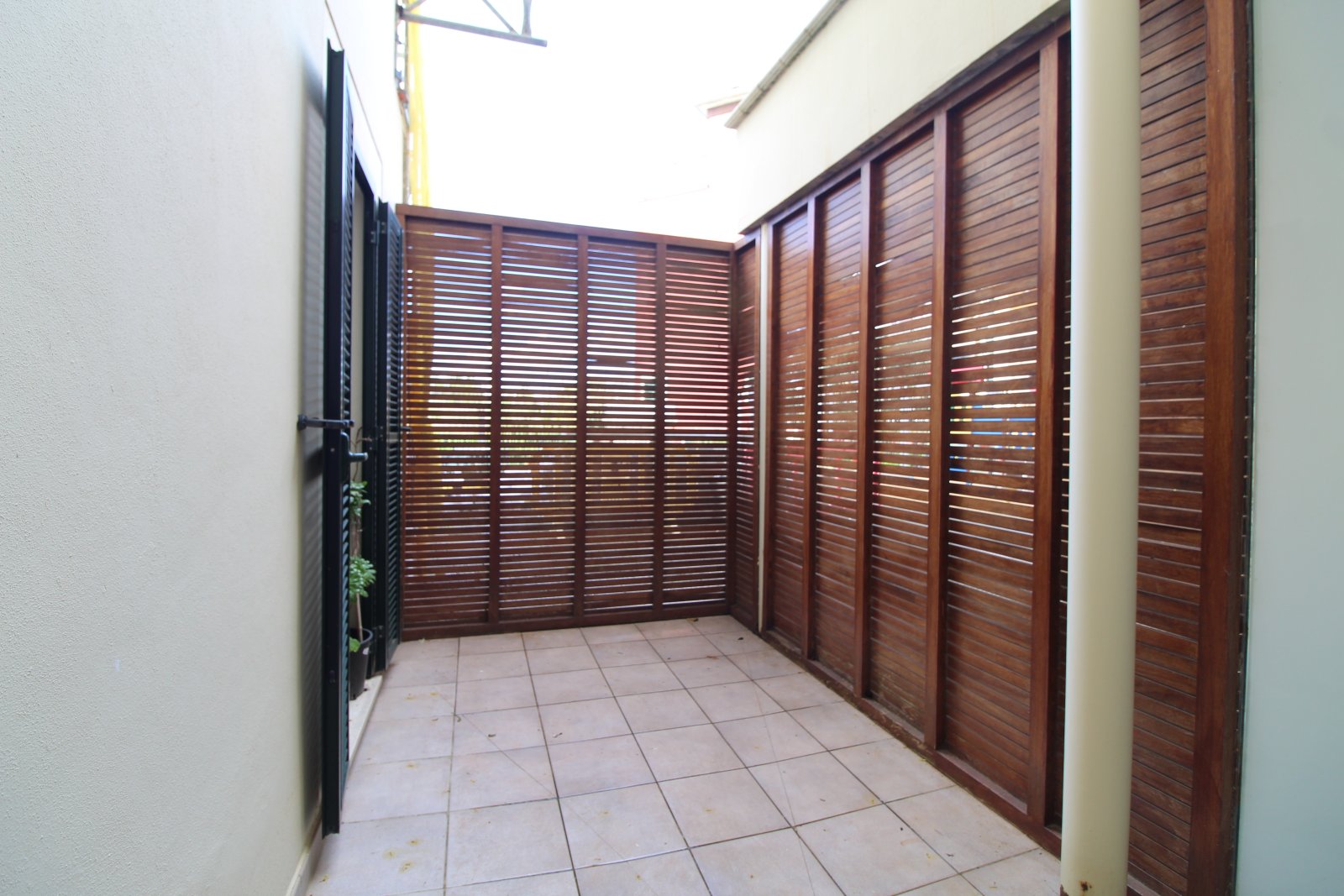 Protected courtyard with high-quality wooden lamella elements and thoughtful zoning