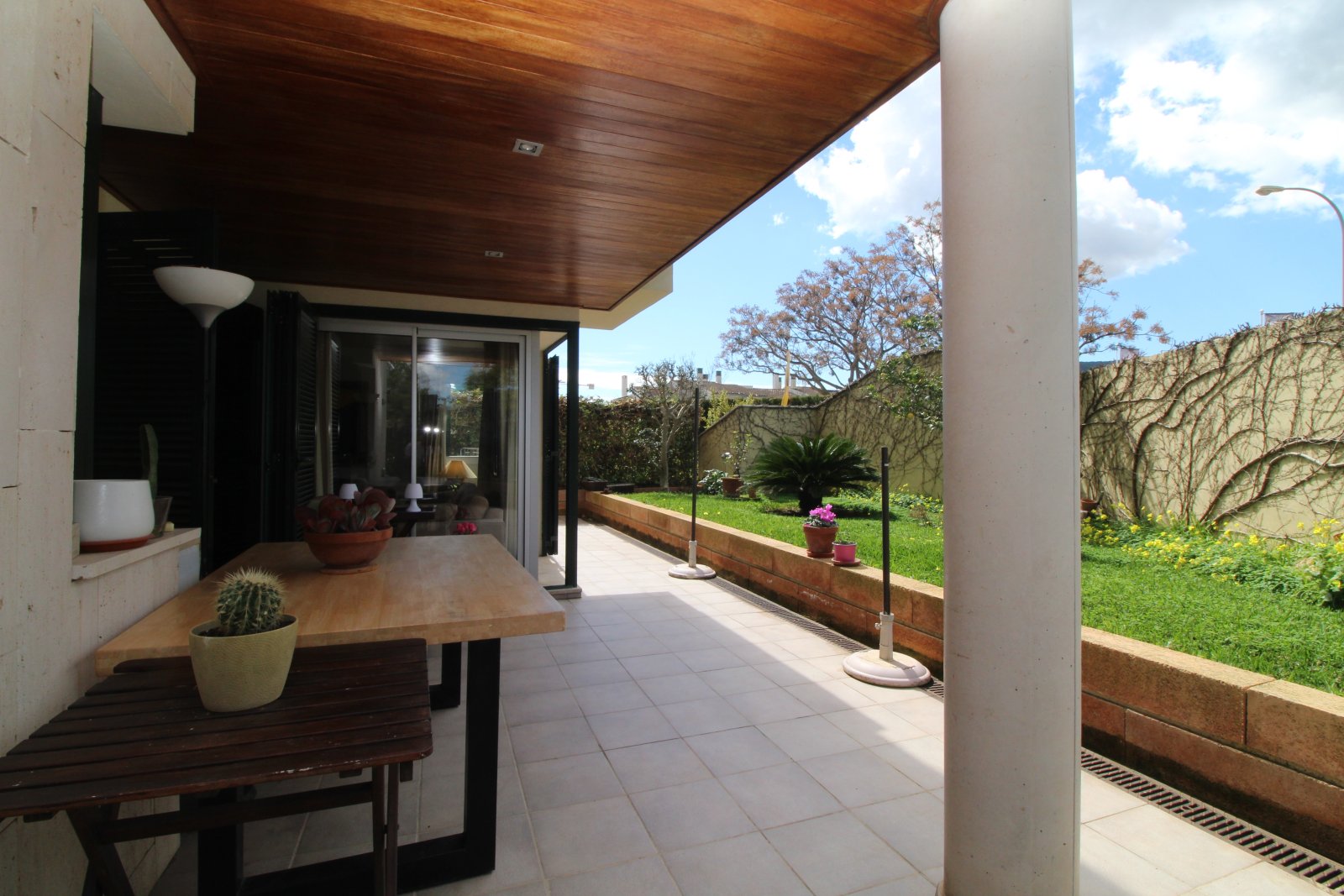Covered terrace with direct garden view and elegant wood ceiling design