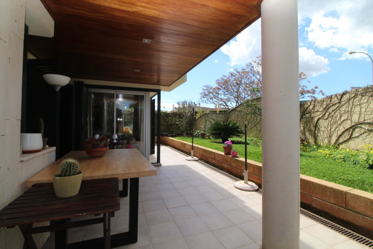 Covered terrace with direct garden view and elegant wood ceiling design