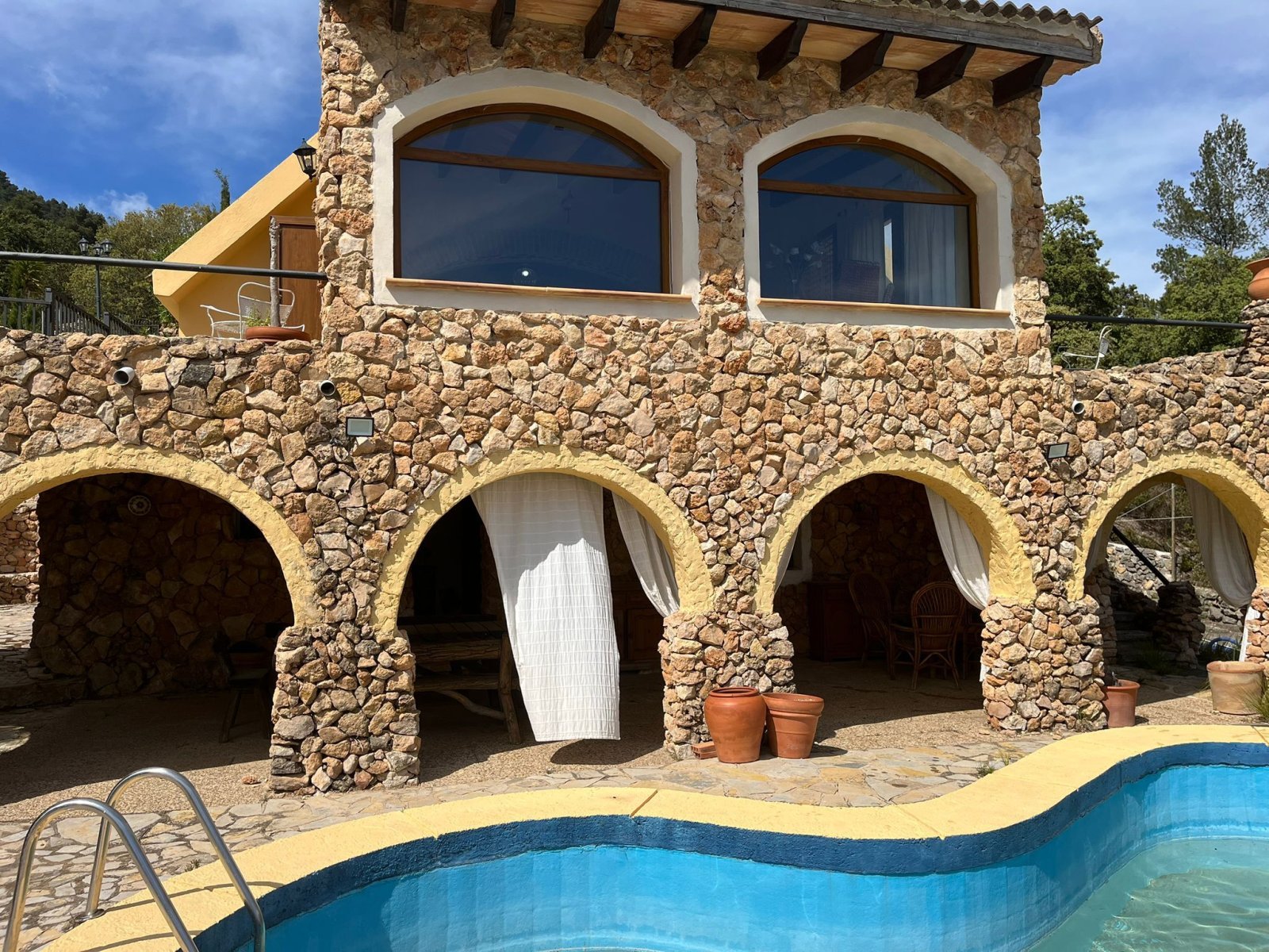 Rustic stone arcades with elegant rounded arches – pool area with distinctive charm