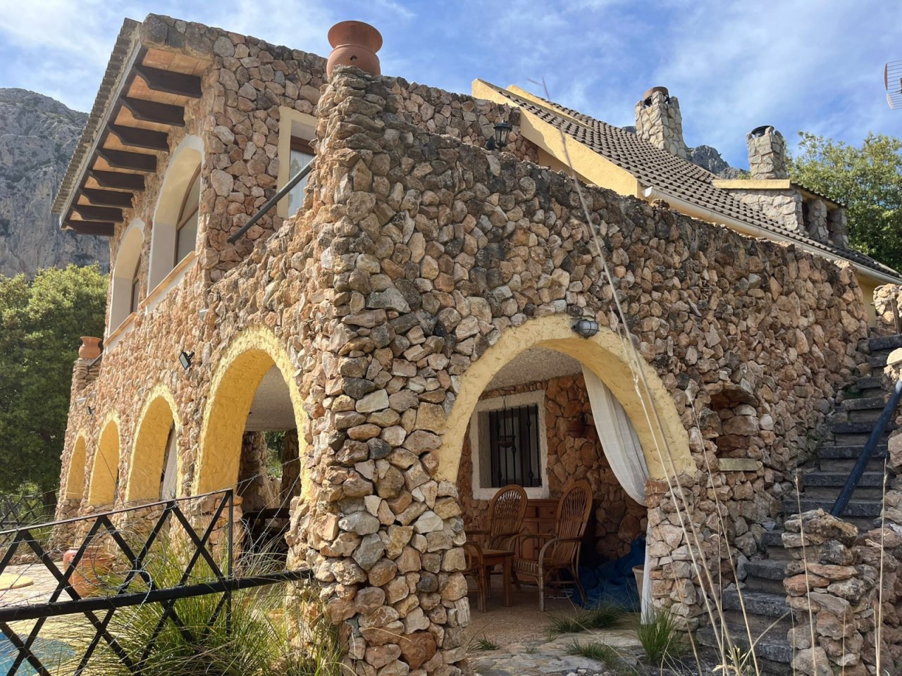 Authentic natural stone architecture with distinctive rounded arch openings – entrance area with rustic Mediterranean charm