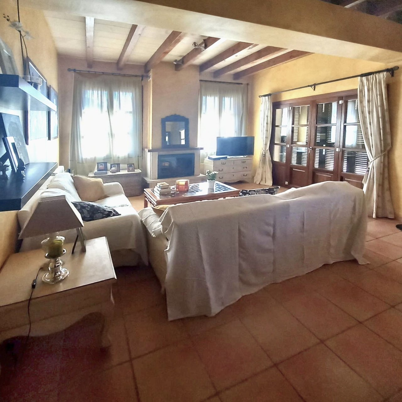 Living/sleeping area with exposed beam ceiling and large glass sliding doors to the outdoor area