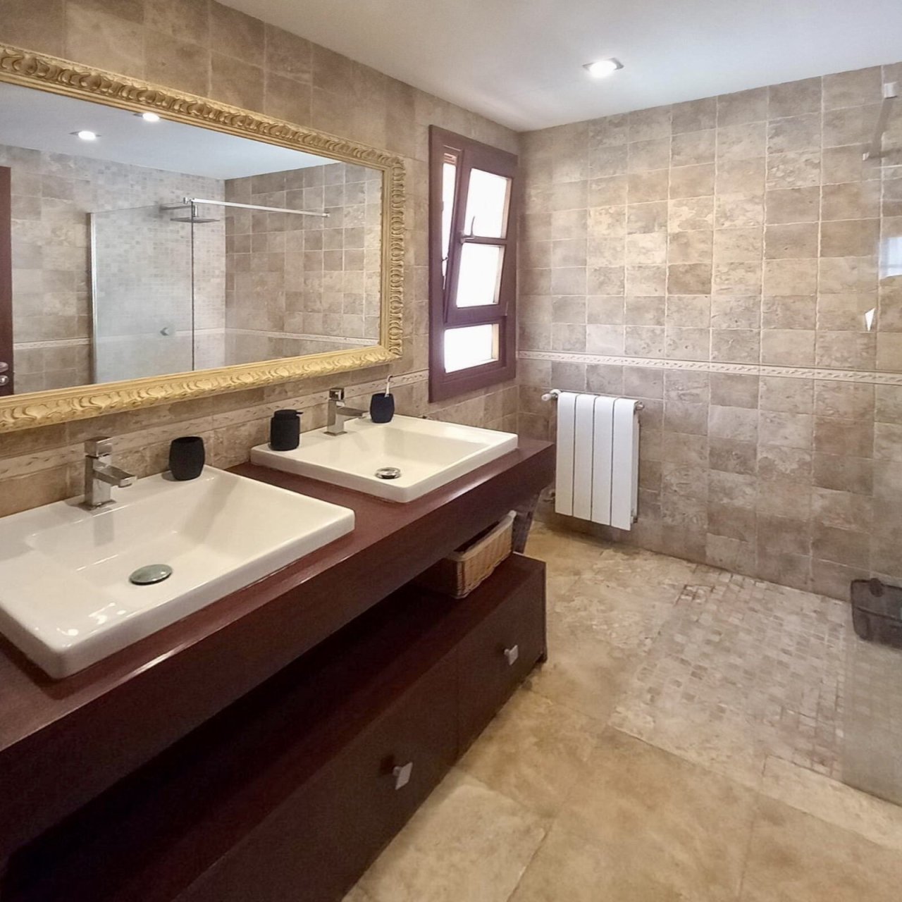 Luxurious bathroom with double vanity, walk-in shower, and high-quality tile fittings.