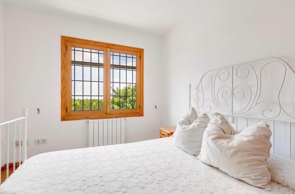 Bright bedroom with large wooden windows and radiator Bright bedroom with large wooden windows and radiator