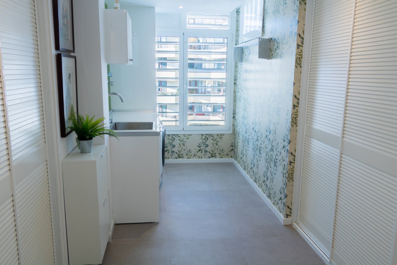 Practical laundry room with functional equipment and bright windows. Practical laundry room with functional equipment and bright windows.