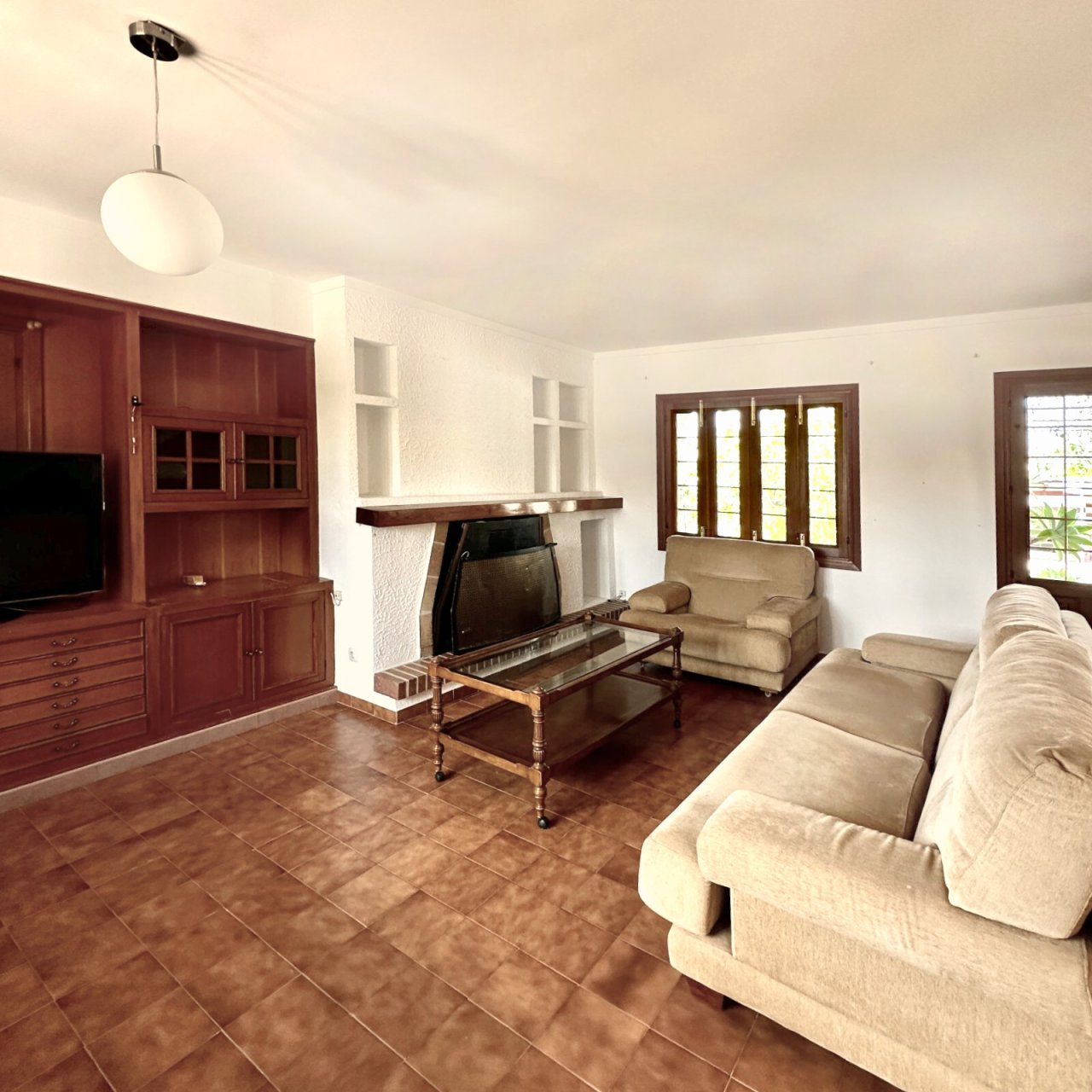 Living room with fireplace, built-in shelves, and terrace access Living room with fireplace, built-in shelves, and terrace access