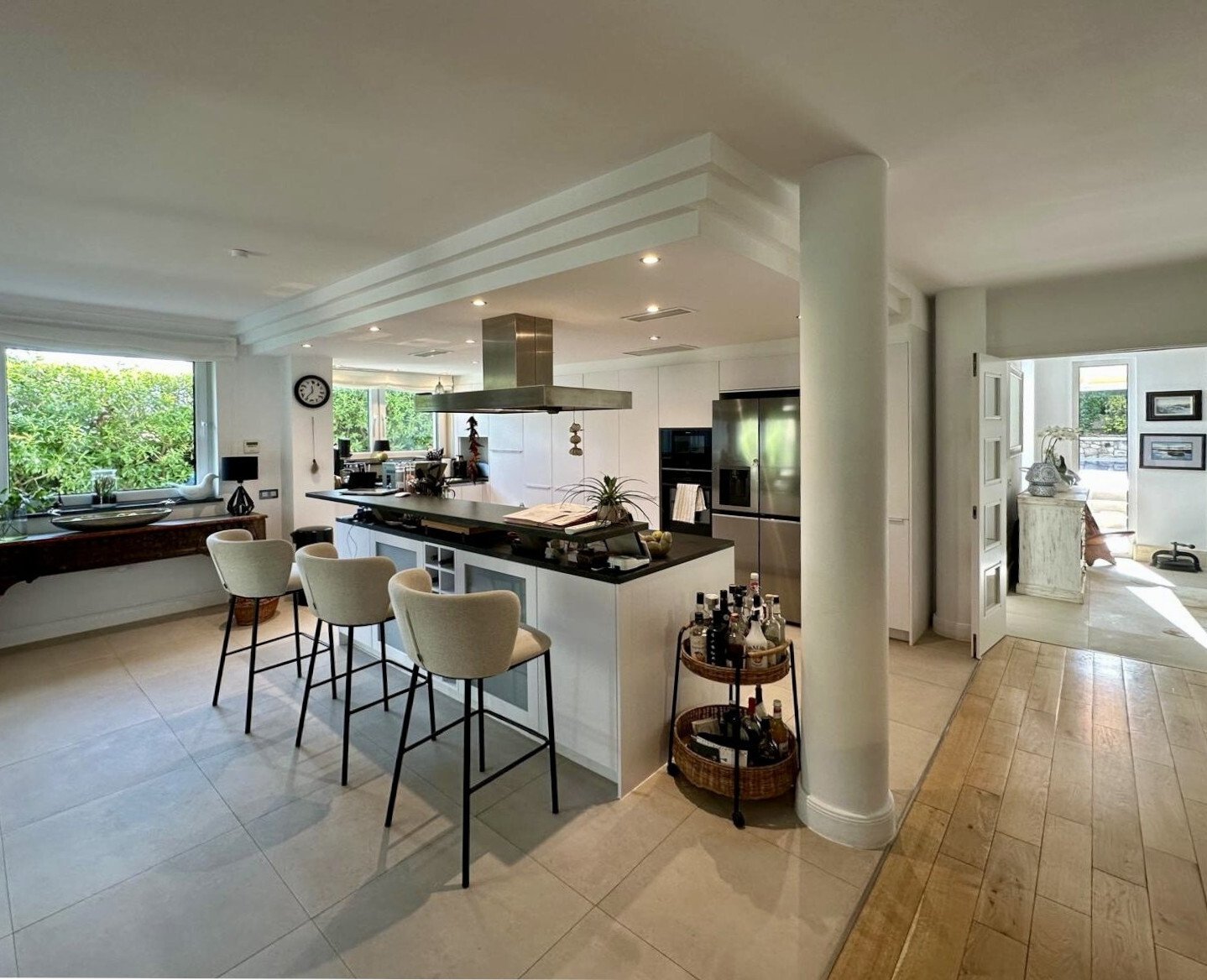 Kitchen with a central island, integrated dining counter, and professional exhaust system – well-designed workspace for modern cooking Kitchen with a central island, integrated dining counter, and professional exhaust system – well-designed workspace for modern cooking