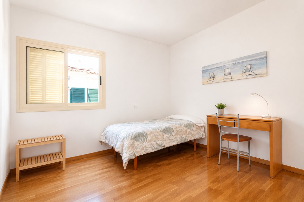 Bright guest room with parquet flooring and large window for natural light Bright guest room with parquet flooring and large window for natural light