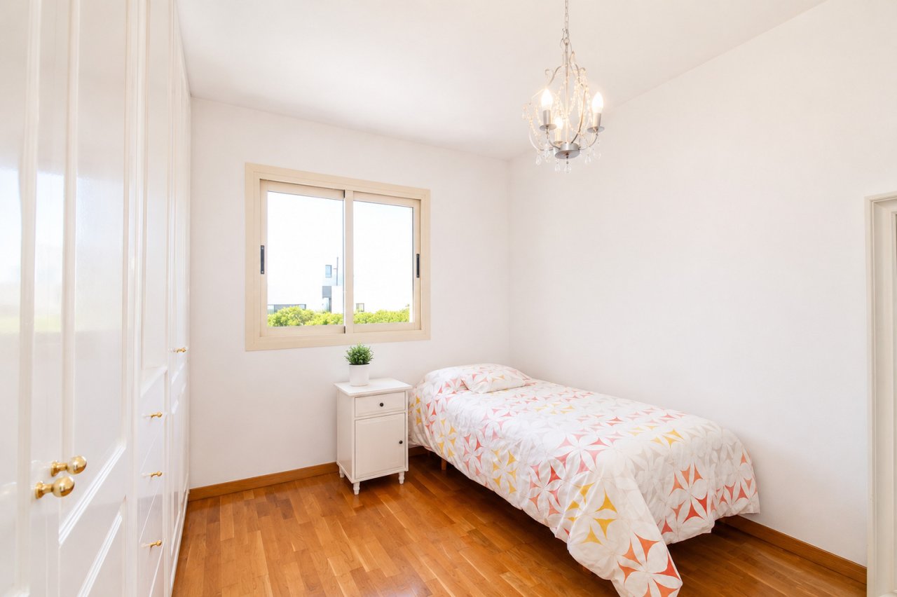 Bright bedroom with large window and high-quality parquet flooring Bright bedroom with large window and high-quality parquet flooring