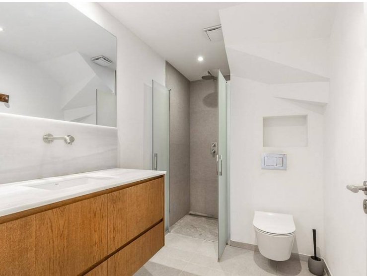 Modern bathroom with walk-in shower and large vanity.