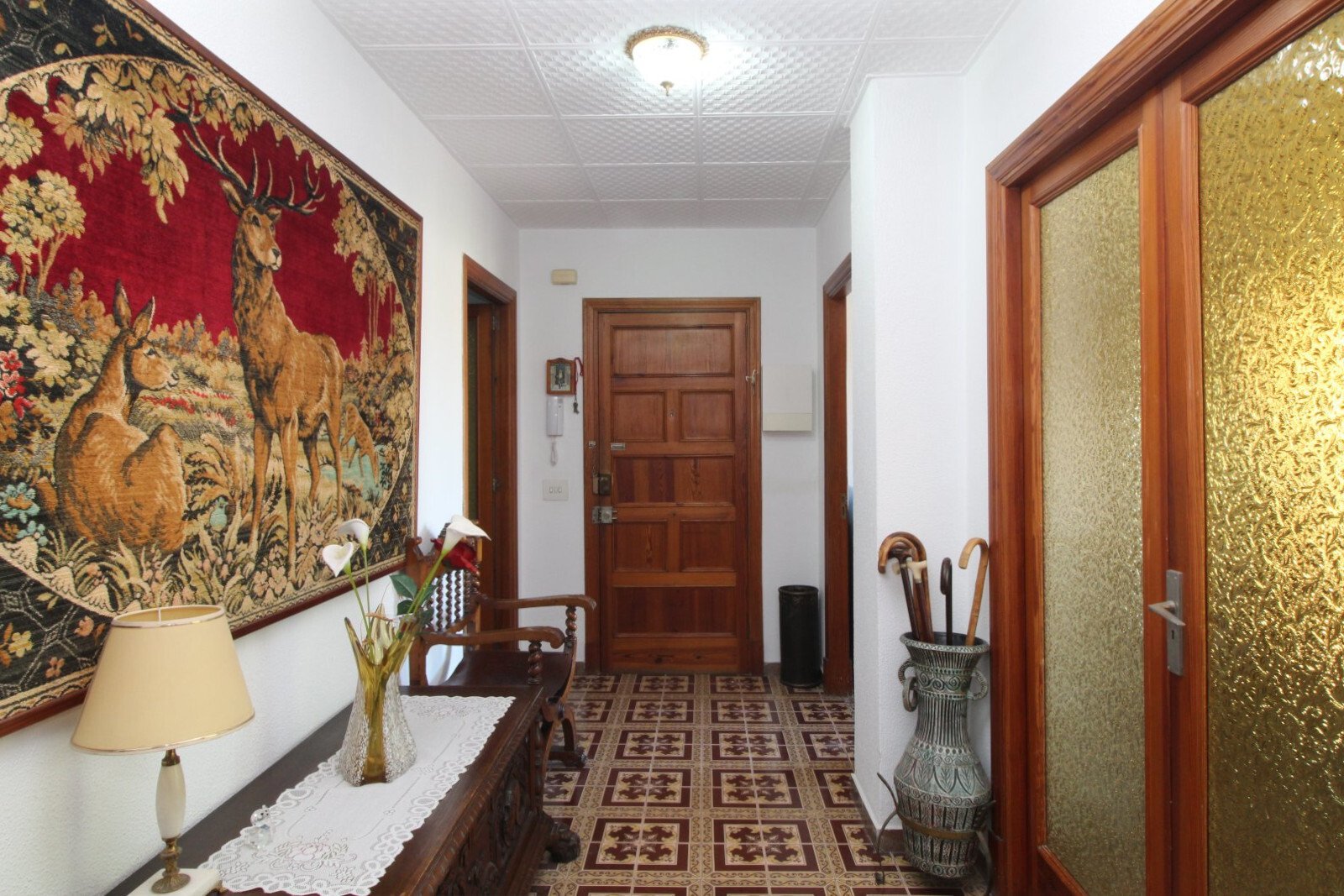 Elegant entrance area with wooden doors, stucco ceiling, and practical room connections. Elegant entrance area with wooden doors, stucco ceiling, and practical room connections.