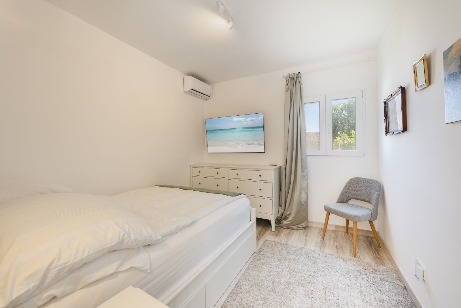 Bright bedroom with air conditioning, window front, and practical storage Bright bedroom with air conditioning, window front, and practical storage