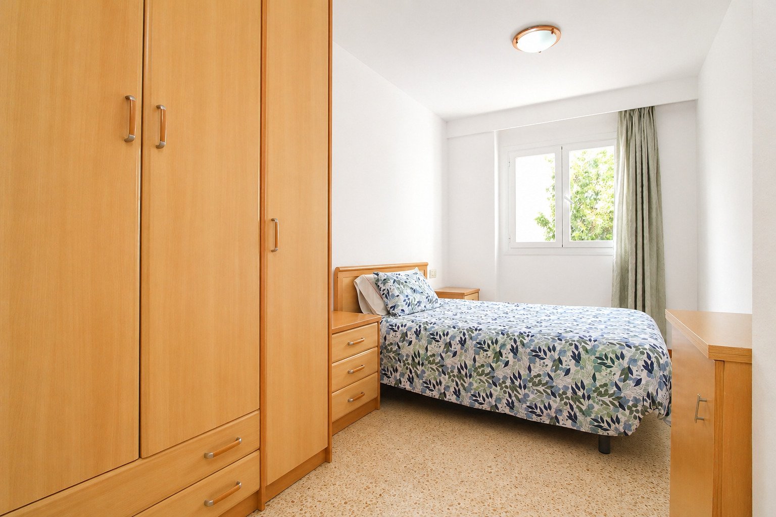 Comfortable bedroom with ample storage space and bright window design Comfortable bedroom with ample storage space and bright window design