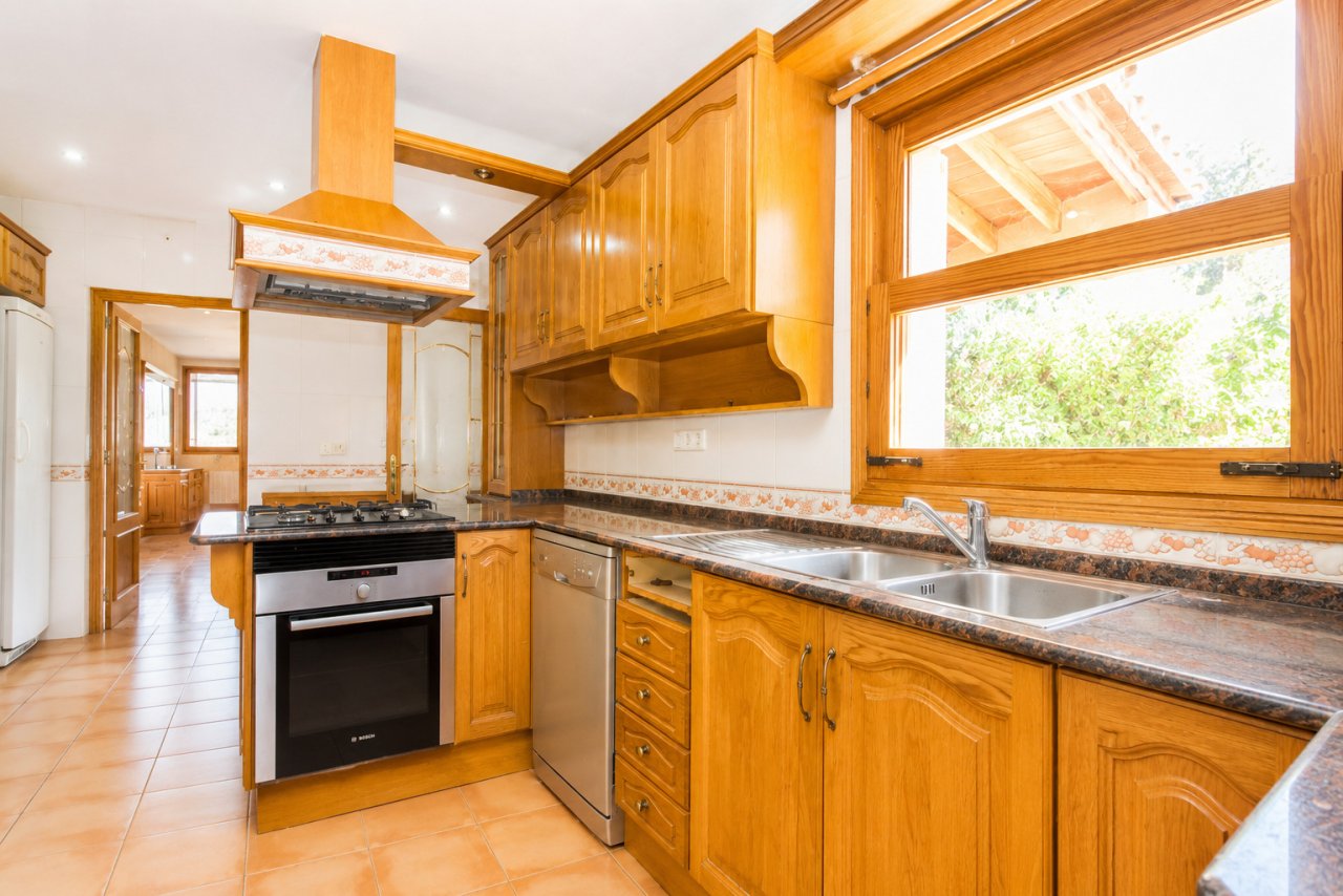 Kitchen with high-quality equipment and large window front overlooking the garden Kitchen with high-quality equipment and large window front overlooking the garden