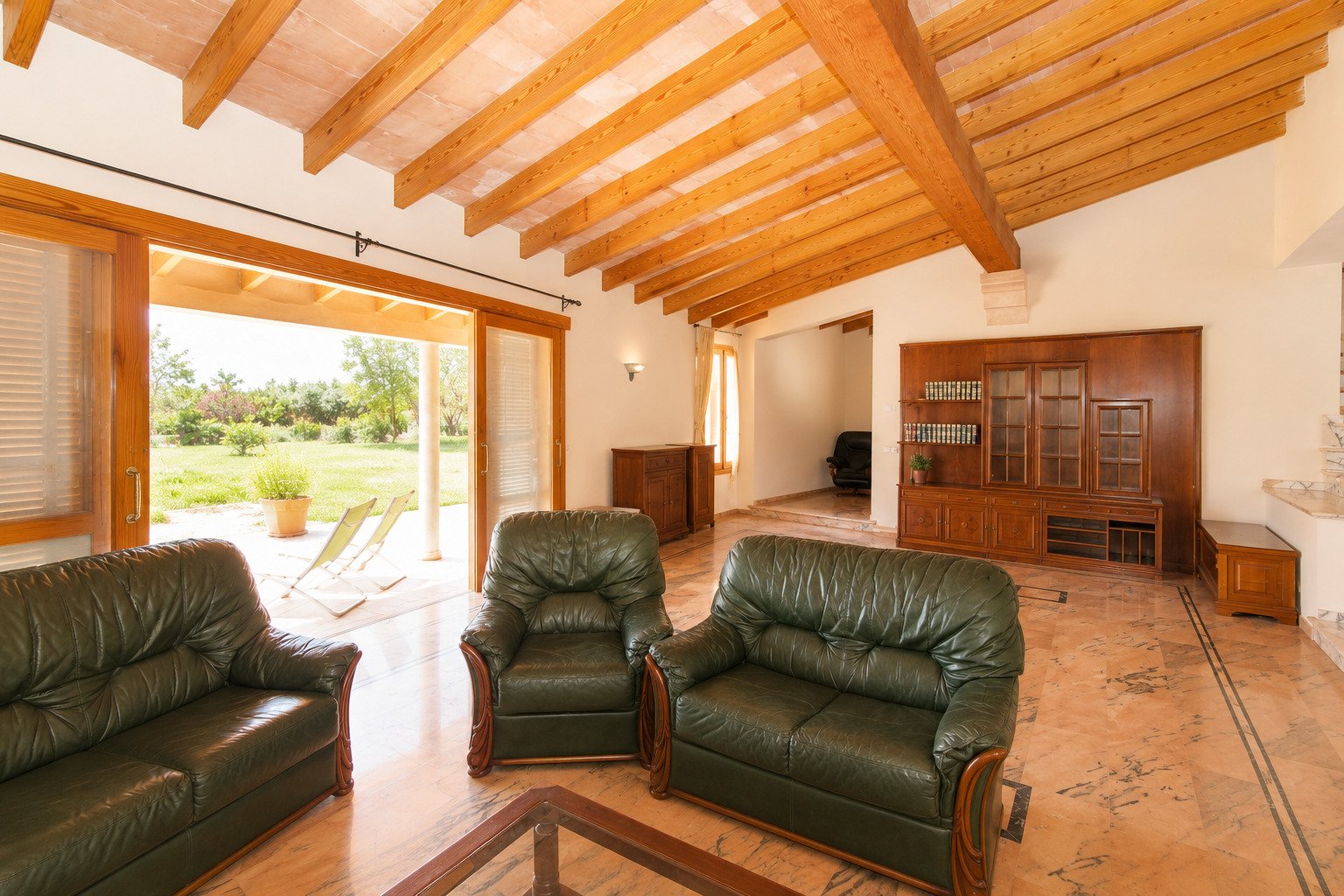 Open living area with rustic wooden beams and large terrace glazing Open living area with rustic wooden beams and large terrace glazing