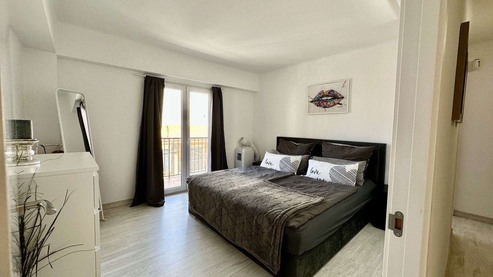 Bright bedroom with balcony access and high-quality furnishings