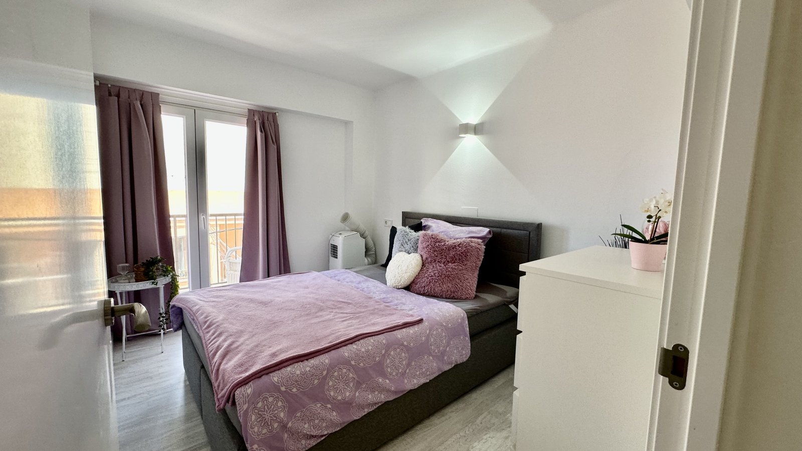 Modern bedroom with balcony access and thoughtful layout
