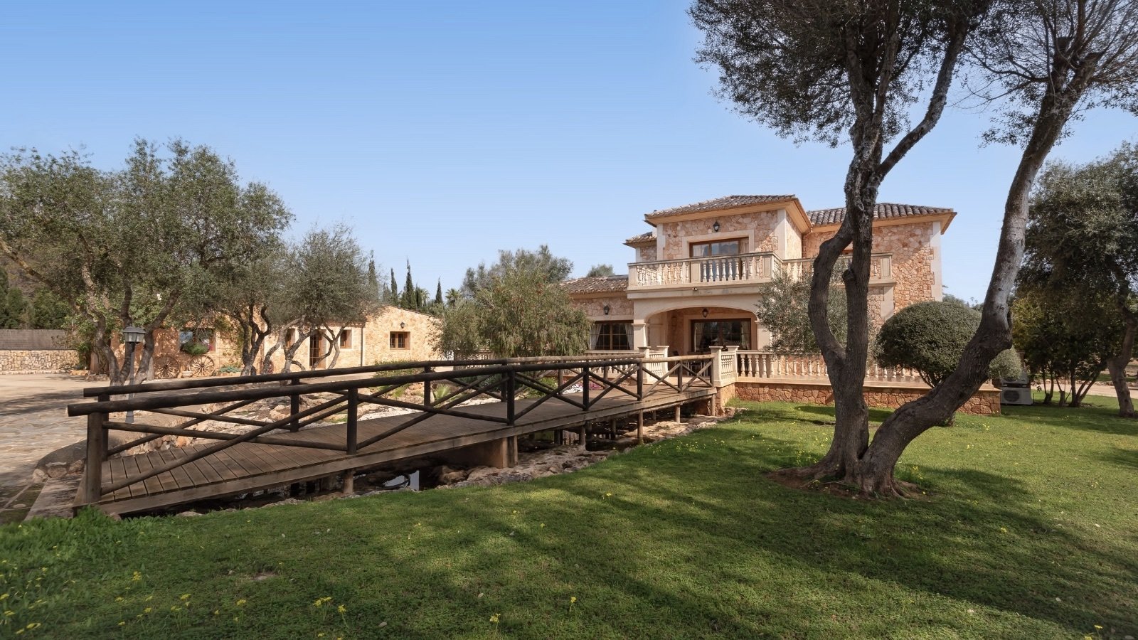 Rustic bridge over an idyllic stream – charming access to the property with a Mediterranean flair
