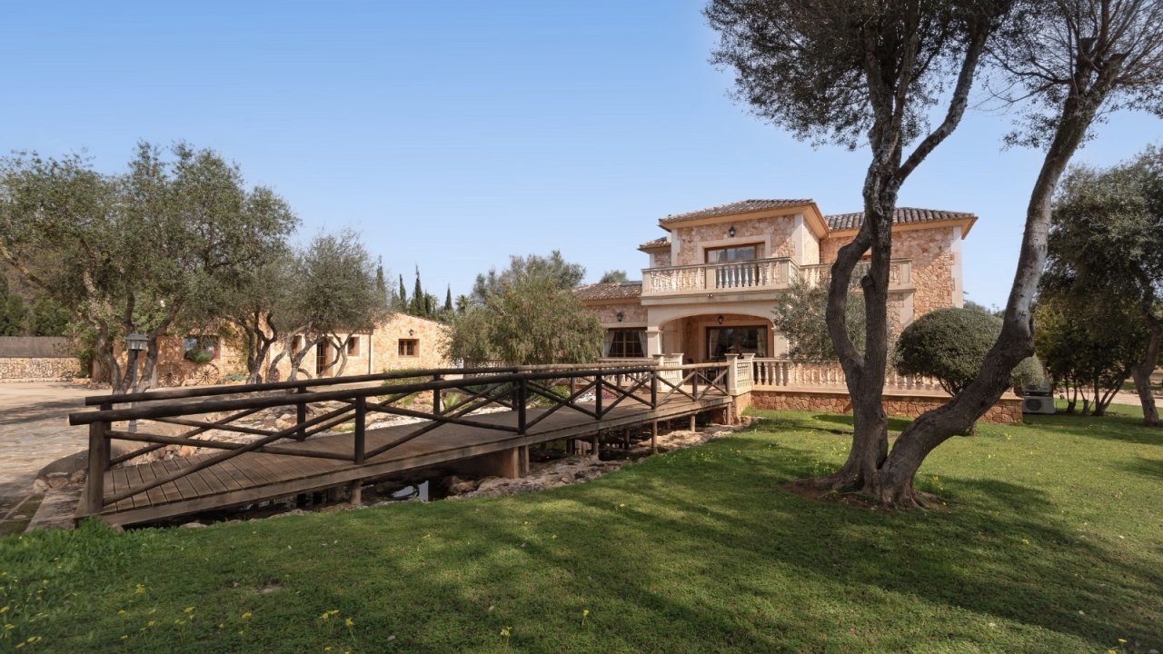 Rustic bridge over an idyllic stream – charming access to the property with a Mediterranean flair