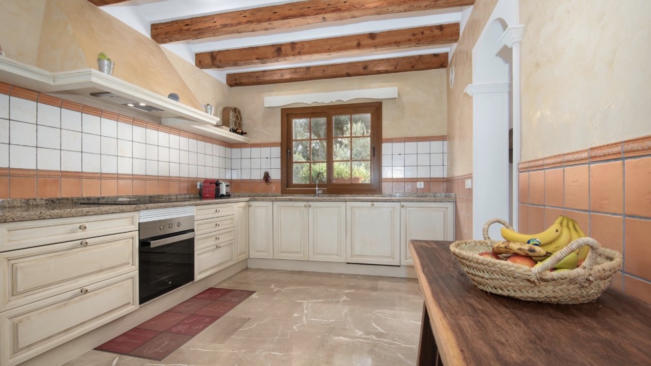 Kitchen with characterful wooden beams and a large window front facing the garden
