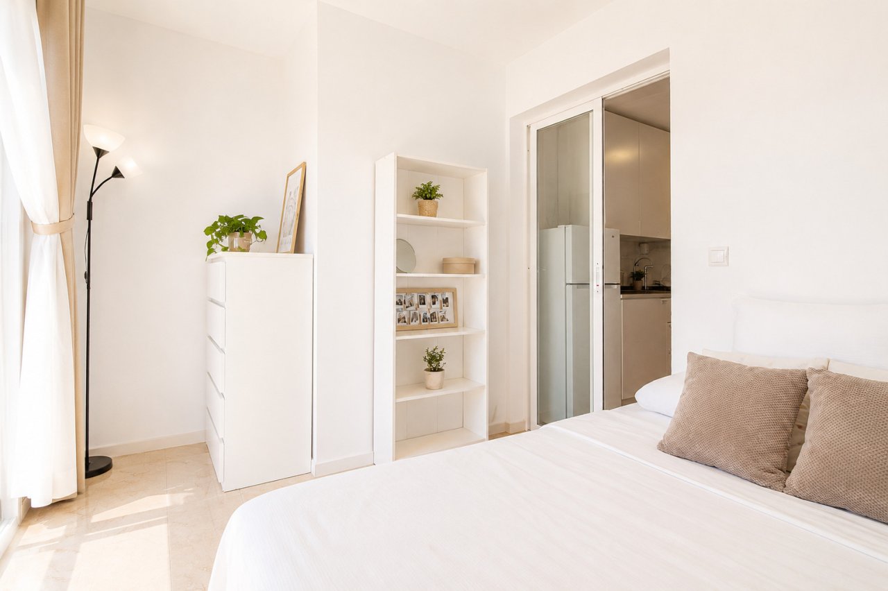 Bedroom with smart storage integration and direct kitchen flow