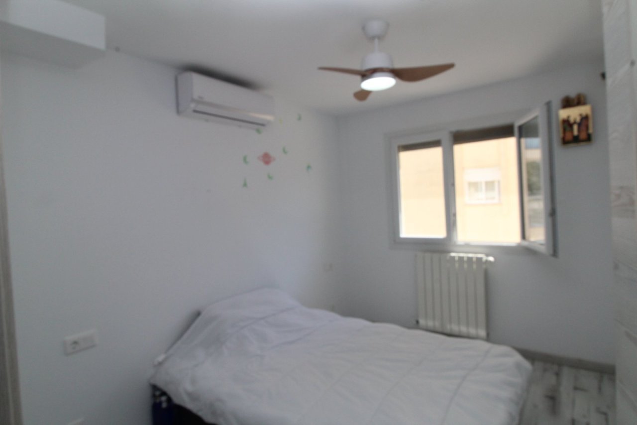 Bright bedroom with air conditioning, ceiling fan, and window facing the street. Bright bedroom with air conditioning, ceiling fan, and window facing the street.