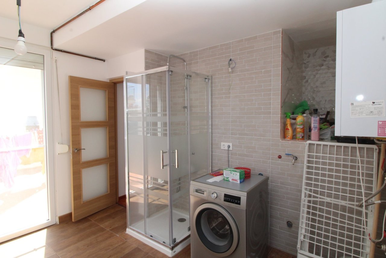 Modern bathroom with walk-in shower and practical washing machine integration Modern bathroom with walk-in shower and practical washing machine integration